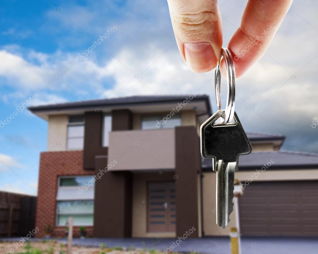 Anahtar tutan el ve arka planda apartman binası